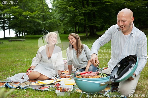 Image of Friends Having Meal At An Outdoor Picnic