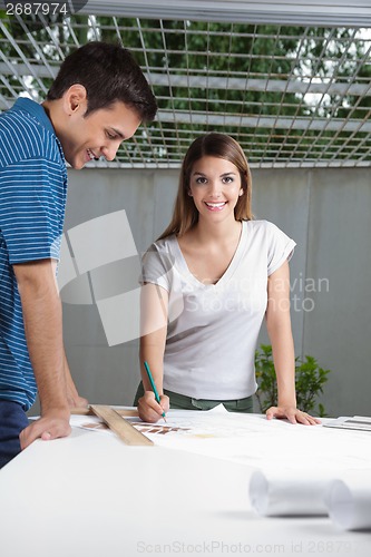 Image of Female Architect Working On Blueprint