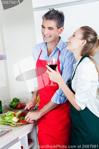 Image of Laughing Couple Cooking in Kitchen