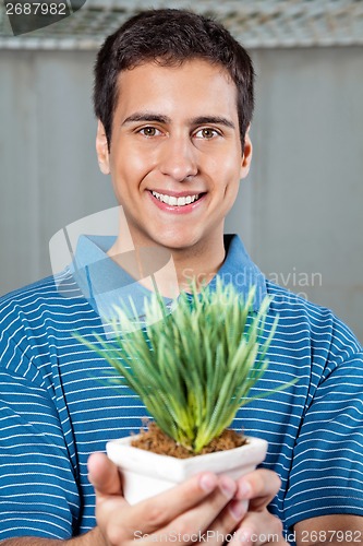 Image of Man Holding Small Plant