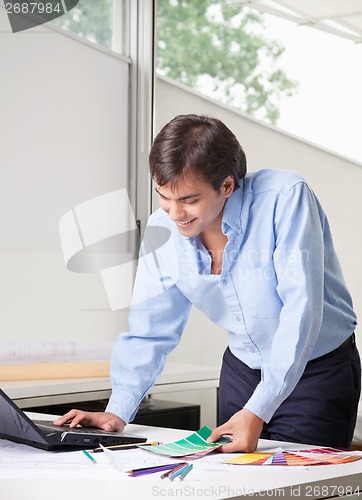 Image of Male Interior Designer Using Laptop