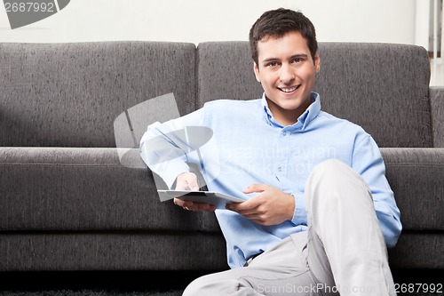 Image of Young Man Holding Digital Tablet