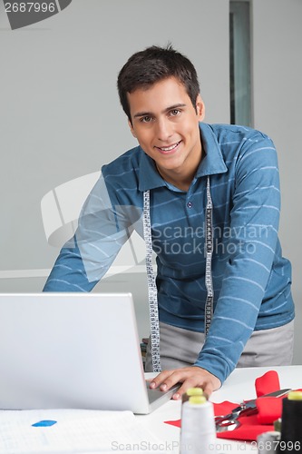 Image of Tailor Using Laptop At Work