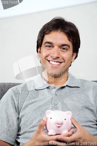 Image of Happy Man Holding Piggybank