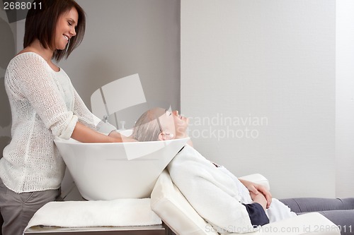 Image of Young Woman Having Hair Wash in Beauty Salon