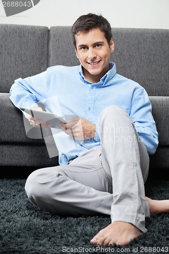 Image of Relaxed Man Holding Digital tablet