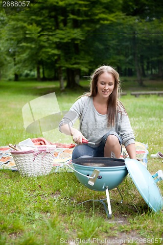 Image of Young Woman Lighting a Barbecue