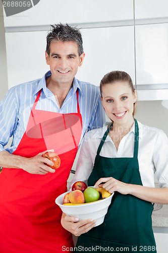 Image of Happy Couple in Kitchen with Fruit
