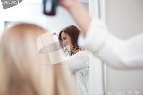 Image of Stylist Drying Womans Hair