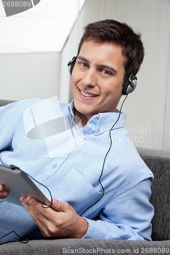 Image of Young Man Listening Music On Digital Tablet
