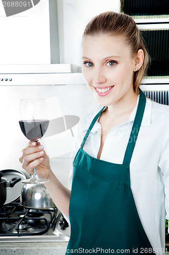 Image of Woman Cooking in Kitchen with Red Wine