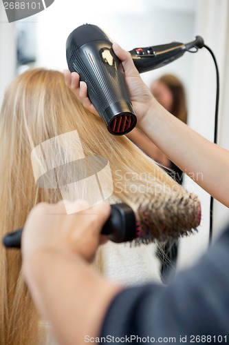 Image of Stylist Drying Woman's Hair In Hairdresser Salon
