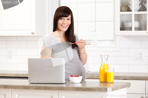 Image of Pregnant Woman in Kitchen Eating Breakfast