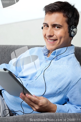 Image of Happy Man Listening Music On Digital Tablet