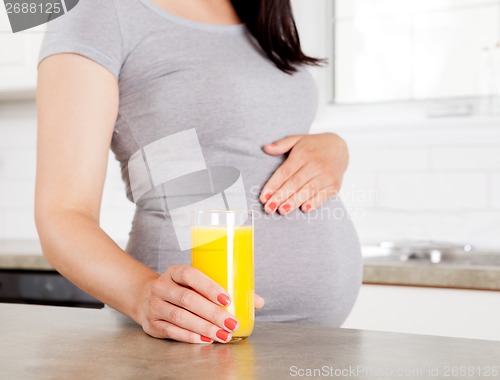 Image of Pregnant Woman Holding Orange Juice