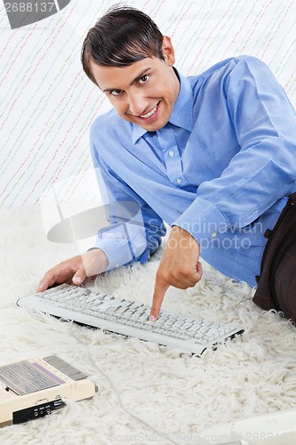 Image of Geek With Computer Keyboard And Cassette Player