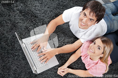 Image of Couple On Rug With Laptop