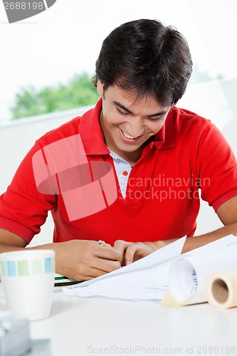 Image of Male Architect Working On Blueprint