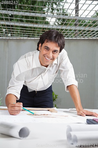 Image of Male Architect Working On Blueprint