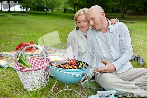 Image of Mature Couple Cooking On An Outdoor Picnic