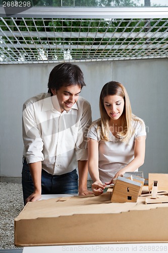 Image of Female Architect Working On Model House