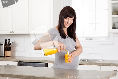 Image of Pregnant Woman Pouring Orange Juice