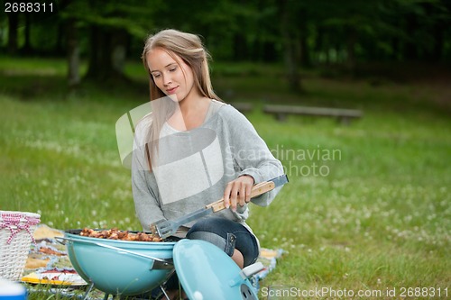 Image of Young Female Cooking Food On Barbecue