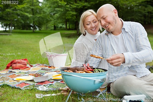 Image of Couple Cooking Meat On Barbecue