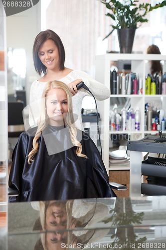 Image of Hairdresser Curling Young Woman's Hair