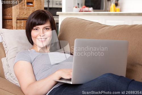 Image of Pregnant Woman on Sofa with Laptop