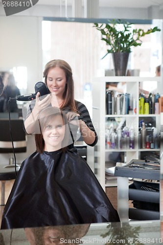 Image of Stylist Drying Woman's Hair