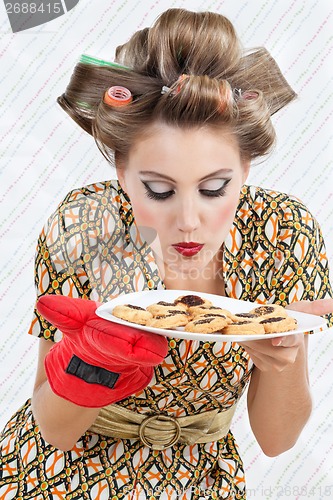 Image of Woman Smelling Plate Of Cookies