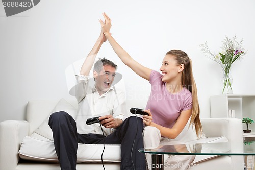 Image of Happy Couple Playing Video Game At Home