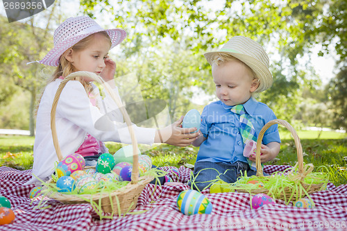 Image of Cute Young Brother and Sister Enjoying Their Easter Eggs Outside