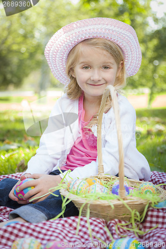 Image of Cute Young Girl Wearing Hat Enjoys Her Easter Eggs