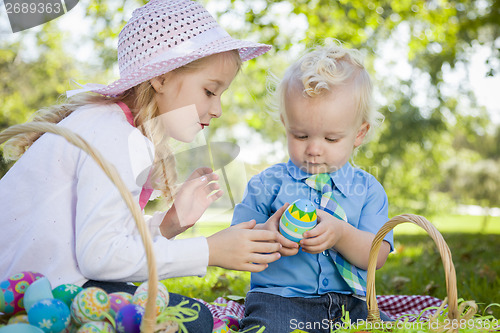 Image of Cute Young Brother and Sister Enjoying Their Easter Eggs Outside