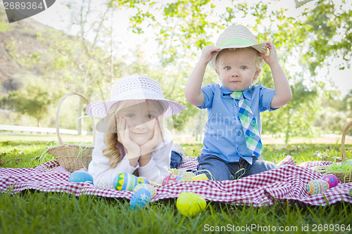 Image of Cute Young Brother and Sister Enjoying Their Easter Eggs Outside