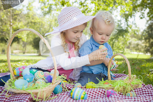 Image of Cute Young Brother and Sister Enjoying Their Easter Eggs Outside