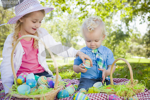 Image of Cute Young Brother and Sister Enjoying Their Easter Eggs Outside