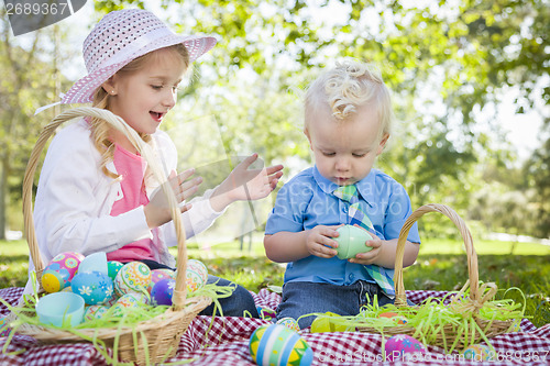 Image of Cute Young Brother and Sister Enjoying Their Easter Eggs Outside