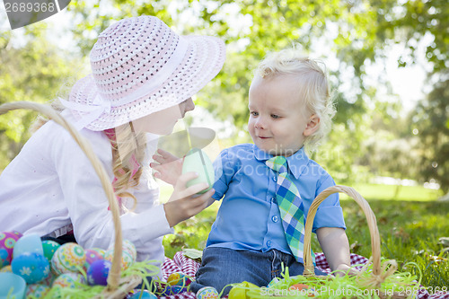 Image of Cute Young Brother and Sister Enjoying Their Easter Eggs Outside