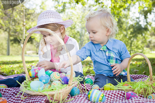 Image of Cute Young Brother and Sister Enjoying Their Easter Eggs Outside
