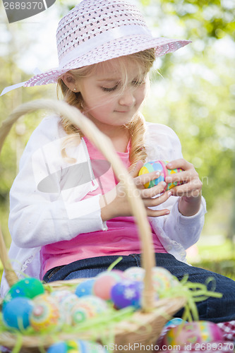 Image of Cute Young Girl Wearing Hat Enjoys Her Easter Eggs