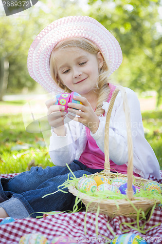 Image of Cute Young Girl Wearing Hat Enjoys Her Easter Eggs