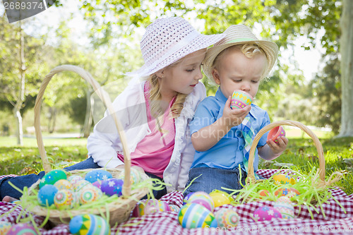 Image of Cute Young Brother and Sister Enjoying Their Easter Eggs Outside