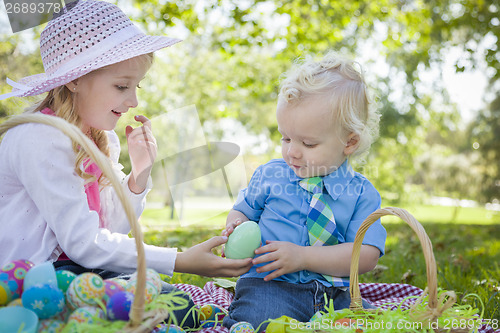 Image of Cute Young Brother and Sister Enjoying Their Easter Eggs Outside