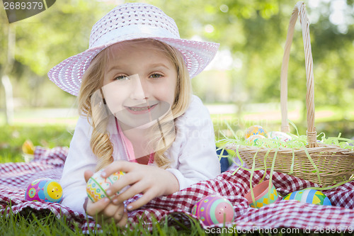 Image of Cute Young Girl Wearing Hat Enjoys Her Easter Eggs
