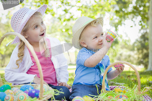 Image of Cute Young Brother and Sister Enjoying Their Easter Eggs Outside