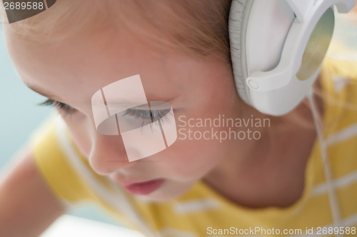 Image of Little blond girl in headphones
