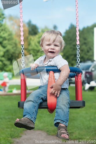 Image of Swinging little boy in denim